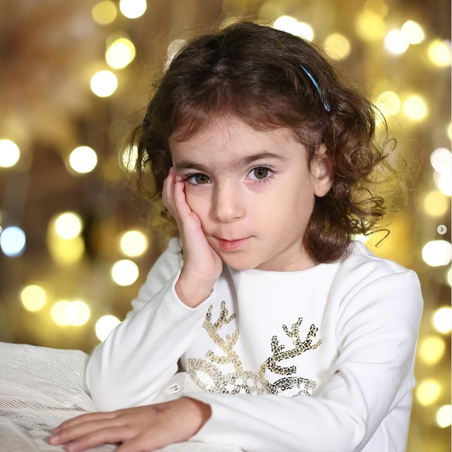 Bambina sorridente tra le luci in sala posa